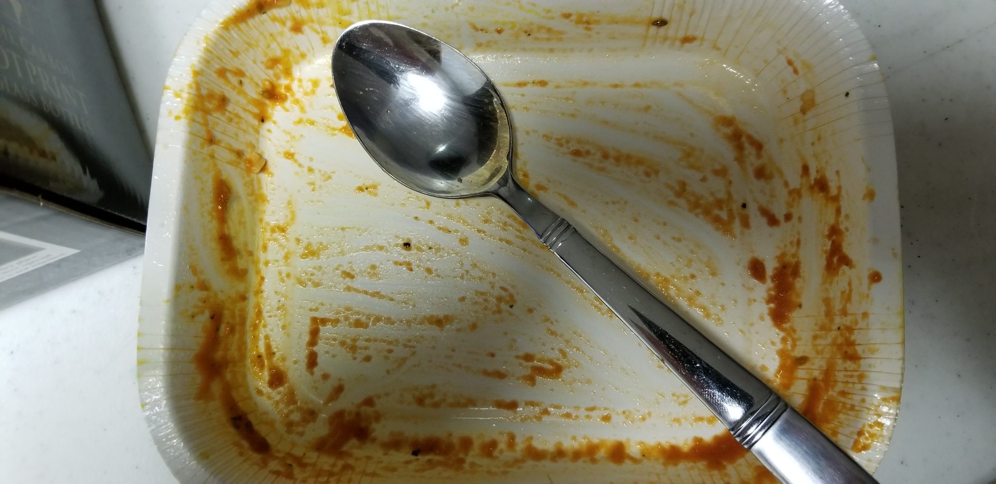 Spoon in empty container of Amy's Paneer Tikka 