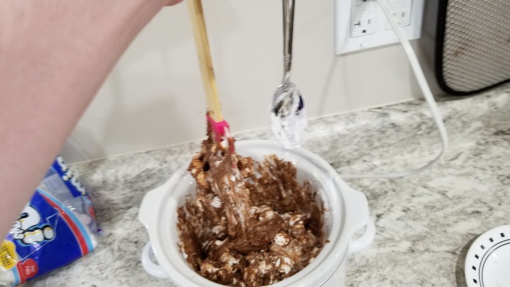 cleaning off a spatula with a spoon