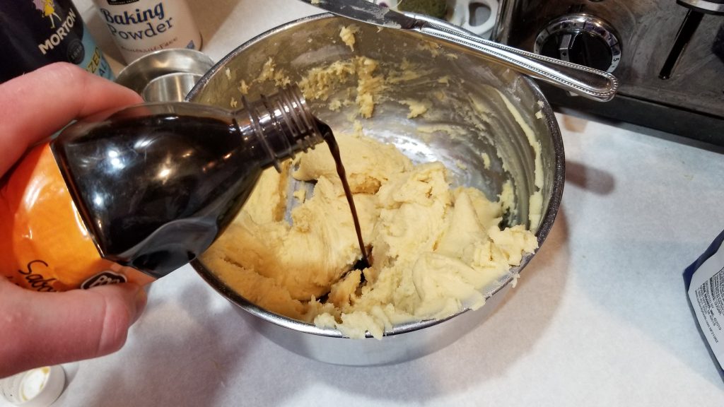 pouring vanilla for a sugar cookie recipe