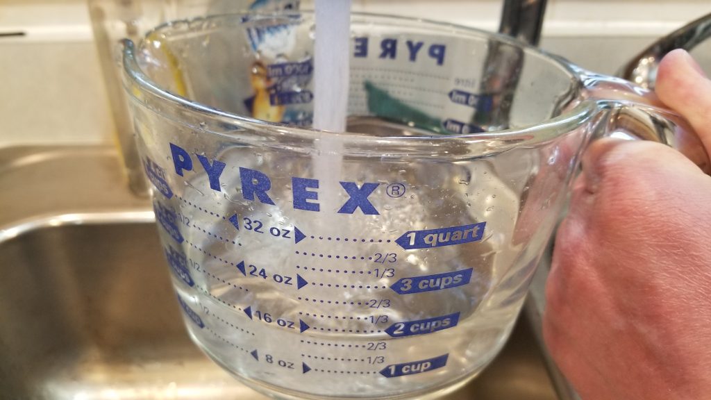 filling up a measuring cup with water