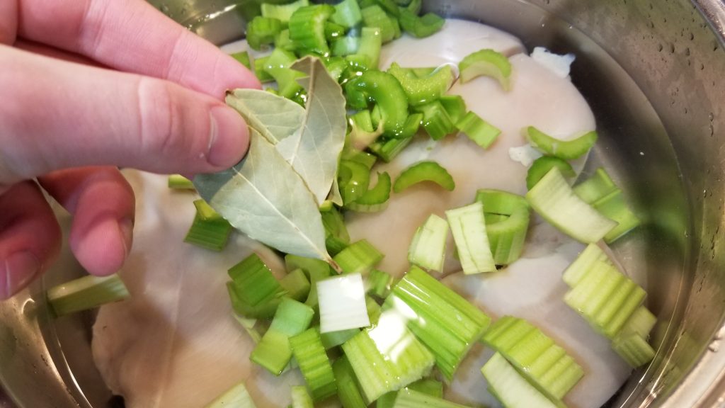 putting bay leaves into chicken salad recipe