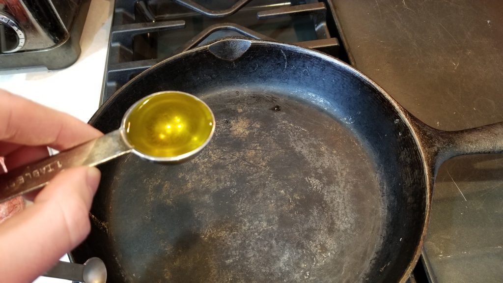 pouring olive oil into skillet