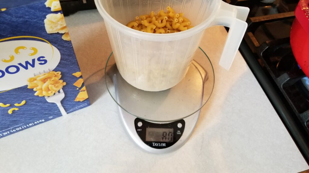 elbows being measured for mac and cheese recipe
