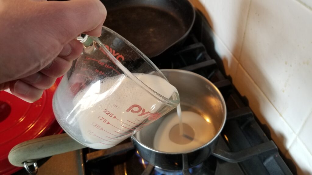 pouring milk for mac and cheese recipe