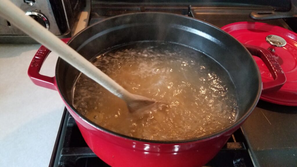 stirring elbow macaroni for mac and cheese recipe
