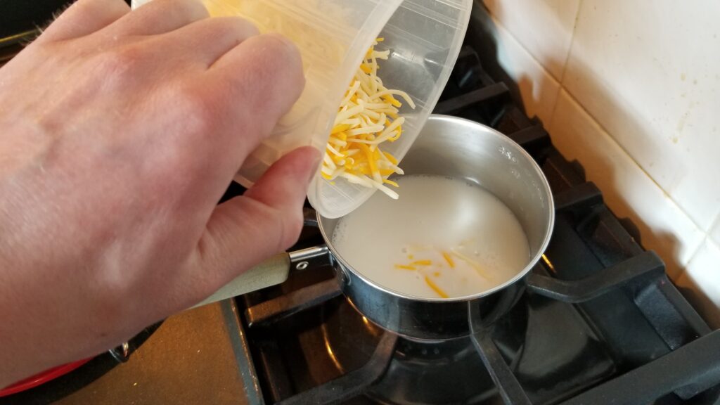 Dumping cheese into milk
