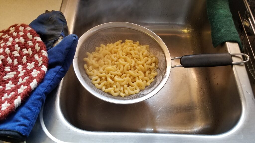 straining elbow macaroni for mac and cheese