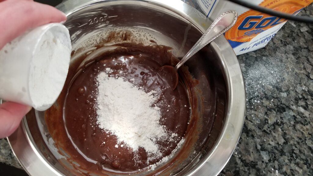 dumping flour into the chocolate