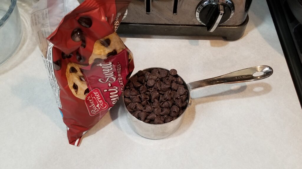 1 cup of chocolate chips measured out for puppy chow recipe