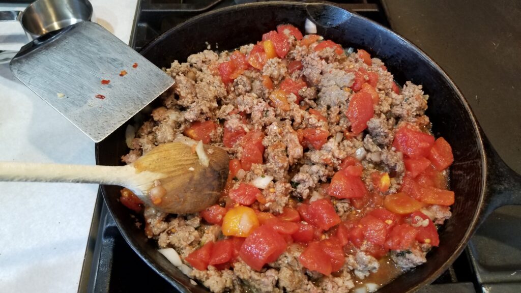 tomatoes and meat in skillet