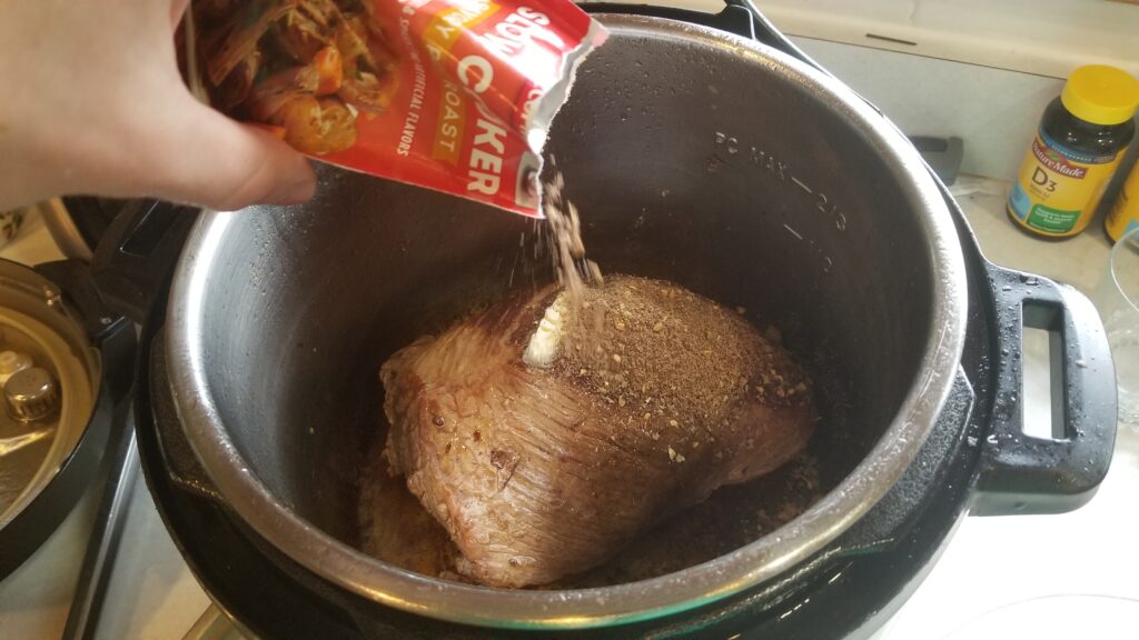 Mississippi pot roast spreading seasoning on it