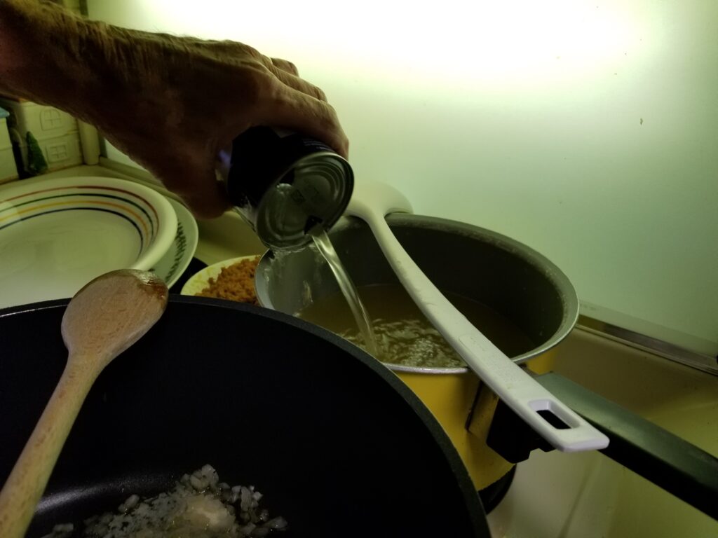 pouring broth into a sauce pan