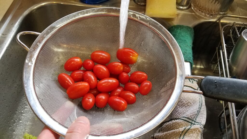 mesh strainer with tiny tomatoes for taco salad recipe