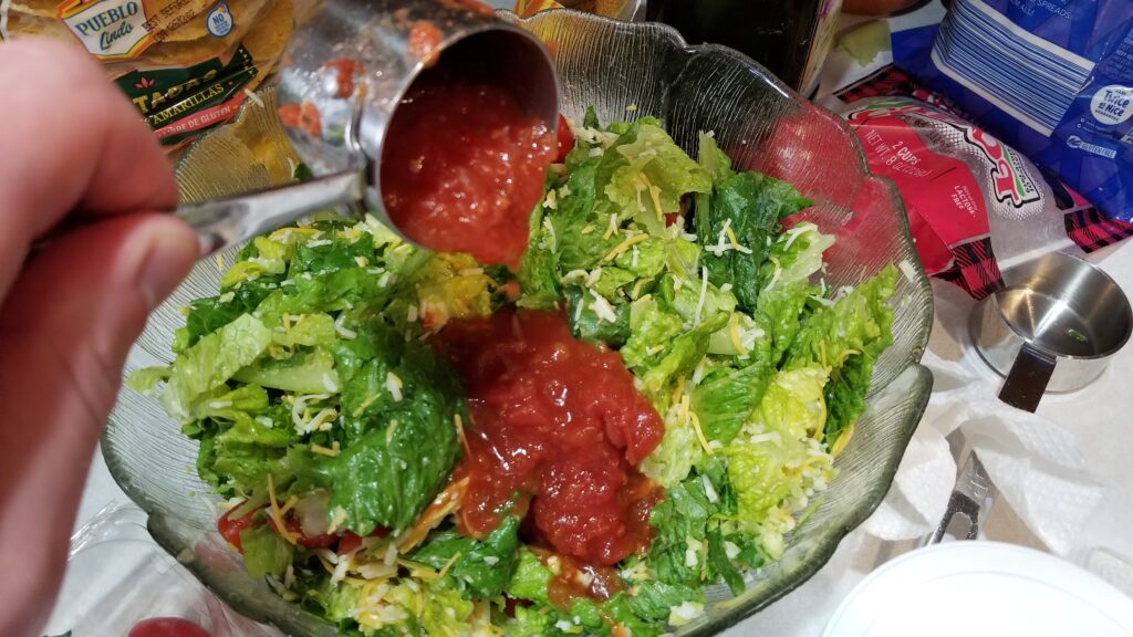scooping salsa for taco salad recipe