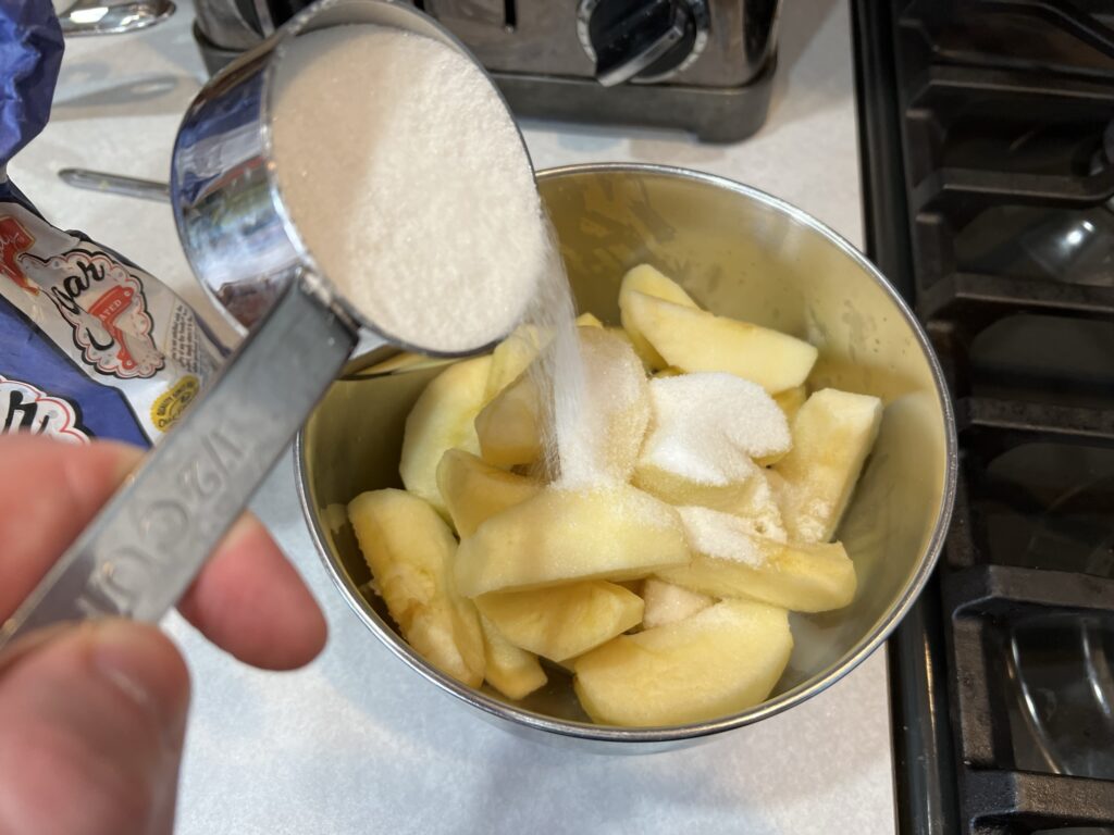dumping sugar into apples