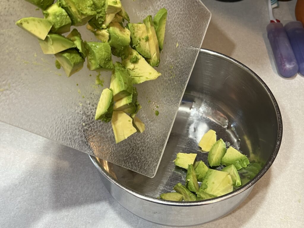 avocado being dumped in bowl