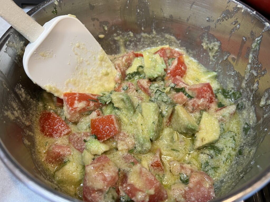 Mixing gemelli pasta salad ingredients