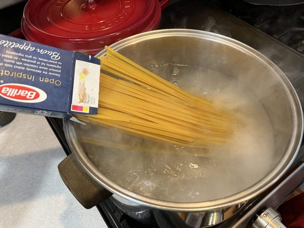 putting pasta in a pot for Tagliolini