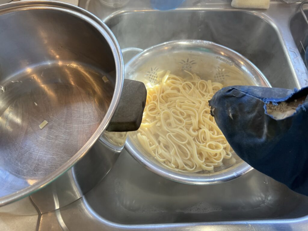draining tagliolini noodles