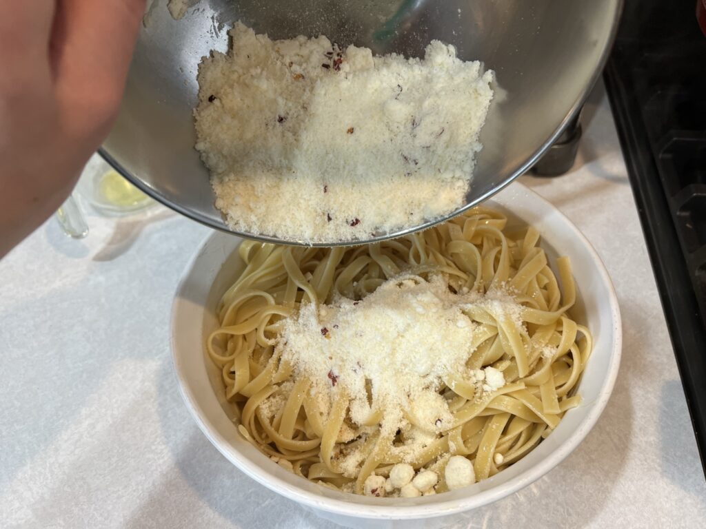 dumping cheese into noodles